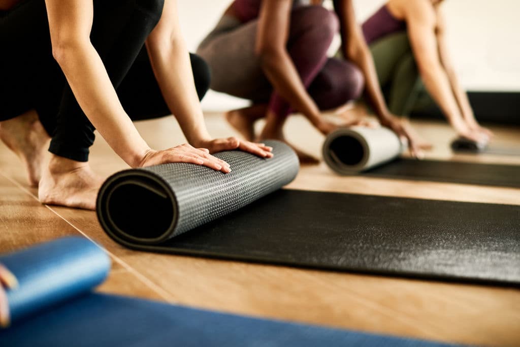 Pilates class rolling out Pilates mats